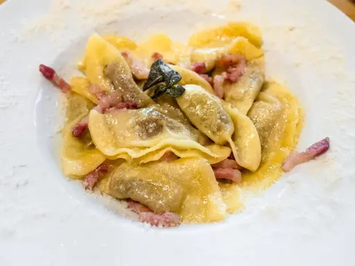 Ravioli ripieni, un piatto tipico bergamasco, conditi con pancetta croccante e salvia.