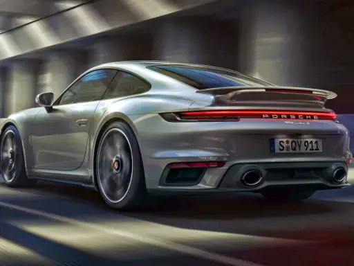 Srebrne Porsche 911 Turbo S pędzi przez tunel. Zastanawiasz się, ile kosztuje Porsche 911?