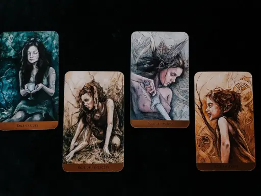 Cztery karty tarota: Pucharów, Monet, Mieczy (page of swords znaczenie) i Buław.