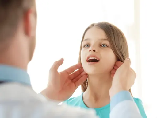 Medico controlla i linfonodi del collo di una bambina.