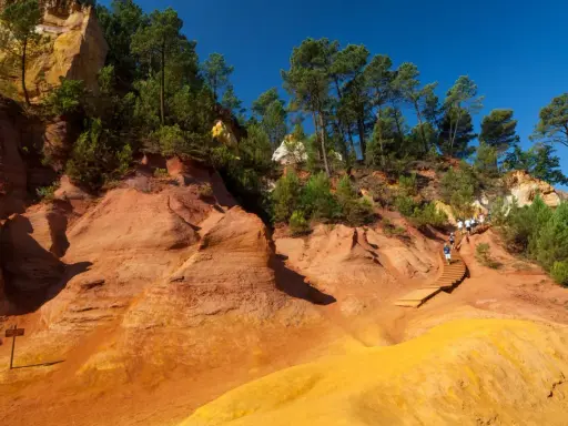 Sentier de randonnée à travers les ocres de Roussillon, où les formations rocheuses rappellent des cheminées de fée.