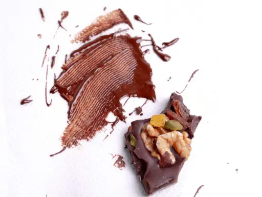 Manchas de chocolate derretido y trozo de chocolate con frutos secos. ¿Cómo quitar manchas que no sabes de qué son?