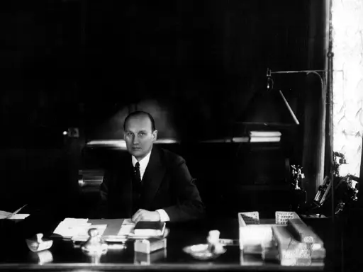 Ivar Kreuger, en svensk ingenjör och industriman, sitter vid sitt skrivbord. En scen som skulle kunna vara från en **Ivar Kreuger film**.