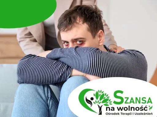Mężczyzna z podbitymi oczami, wspierany przez drugą osobę, szuka drogi, jak wyjść z uzależnienia. Logo "Szansa na wolność".