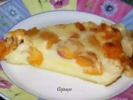 Tranche de clafoutis aux mirabelles alsacienne, dorée et gourmande, sur une assiette décorée.