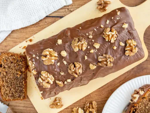 Saftiger Walnusskuchen mit Schokoladenglasur und ganzen Walnüssen. Dieses Rezept für Walnusskuchen ist ein Genuss!
