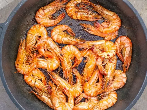 Saftige, tiefgefrorene Garnelen mit Schale werden in einer Pfanne zubereitet. Sie sind perfekt für ein schnelles Abendessen.