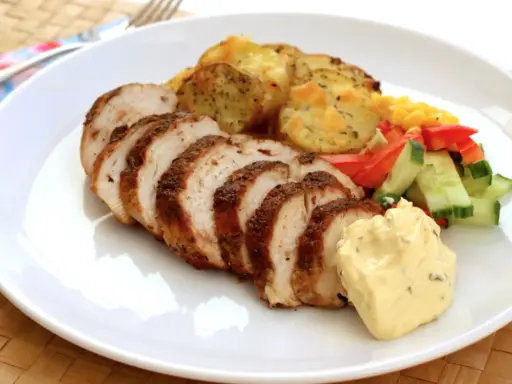 Skivad kycklingfilé i ugn, perfekt tillagad med krispiga potatisskivor, färsk sallad och en klick krämig sås.