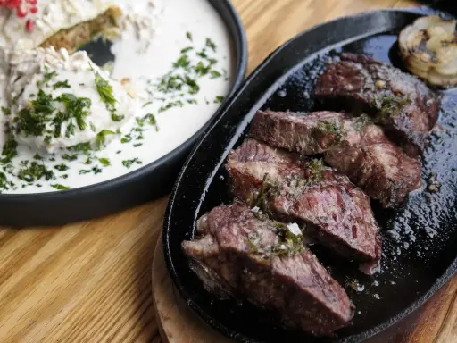 En saftig argentinsk grillfest med perfekt stekt kött och en krämig rätt med örter.