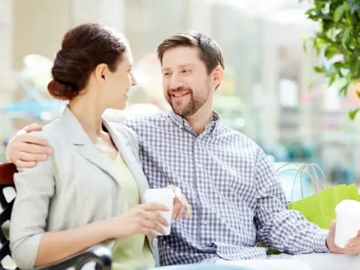 Pareja sonriente compartiendo un café, un ejemplo de comunicación efectiva.