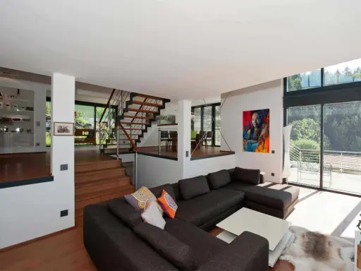 Moderne Wohnlandschaft mit offenem Treppenhaus und Kunstwerk. Tolle split-level haus ideen für ein geräumiges Zuhause.
