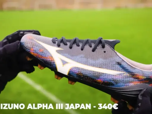 Ręce w rękawiczkach trzymają kolorowe korki Mizuno Alpha III Japan, które mogą być najlepszymi korkami na świecie.