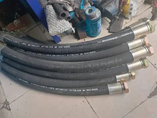 Plusieurs tuyaux hydrauliques BOTONG, chaque tuyau serti avec des raccords métalliques, prêts pour l'installation.