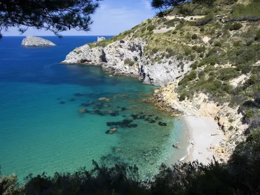 La cala del gesso, Monte Argentario, offre acque cristalline e una spiaggia appartata tra rocce e macchia mediterranea.