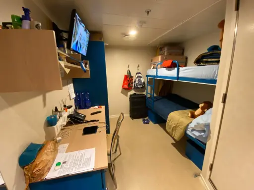 Cosa trovo in cabina Costa Crociere: letti a castello, scrivania con TV, valigie e un peluche.