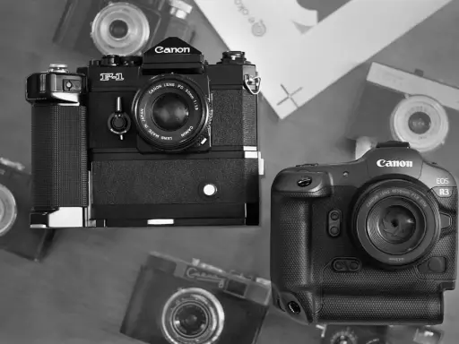 Dwa aparaty Canon: starszy model F-1 i nowoczesny EOS R3, otoczone innymi aparatami.