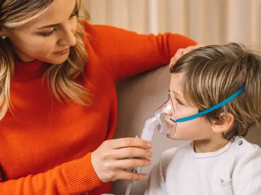 Mamma assiste il bambino con un inalatore per alleviare il broncospasmo.