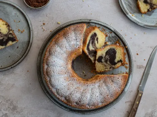 Ein köstlicher Marmorkuchen, frisch gebacken und mit Puderzucker bestäubt. Dieses Marmorkuchen Rezept ist ein Klassiker.