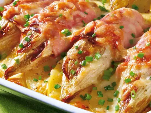 Gebackener Chicorée in Schinken gewickelt, überbacken mit Käse und Kartoffeln. Ein köstliches Gericht für alle, die Rezepte mit Schinken lieben.