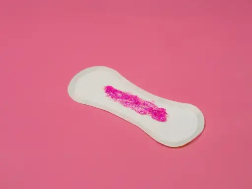 Compresa con brillo rosa simulando que la regla solo mancho al limpiarme.