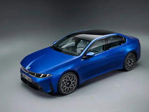 Blauer BMW i3 Neue Klasse Limousine mit schwarzem Dach und futuristischen Felgen.