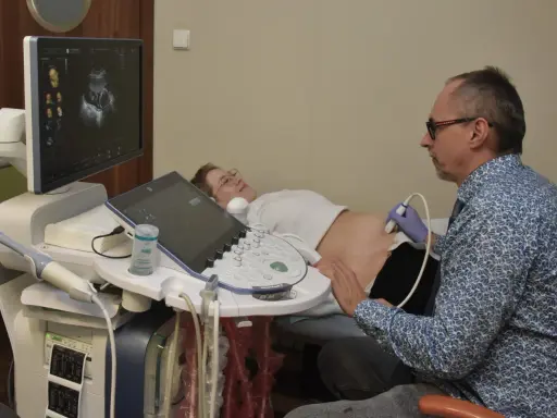 Lekarz wykonuje usg 3 trymestru. Na ekranie widać obraz dziecka, a pacjentka leży spokojnie.