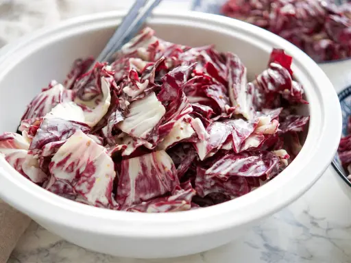 Ein cremiger Radicchio Salat in einer weißen Schüssel, bereit zum Servieren.