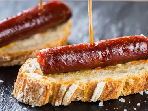 Pinchos de chorizo, un clásico de la comida típica de Navarra, servidos sobre pan rústico.