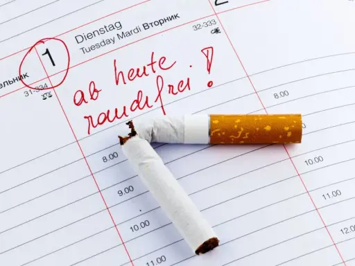 Ein Kalenderblatt mit dem Datum 1. markiert und der Aufschrift "ab heute rauchfrei!". Eine zerbrochene Zigarette liegt darauf. Ein Symbol für eine raucherlunge nach 5 jahren.