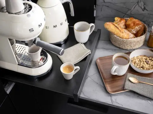 Kaffeebar zu Hause einrichten: Espresso, Müsli und Gebäck auf einem Tablett.