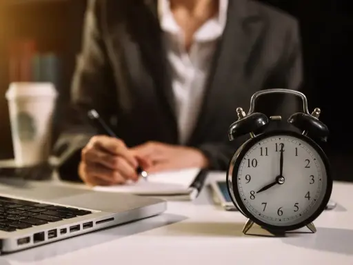 Zegar pokazuje 8:00. Osoba pisze notatki, pracując w grudzień dni pracujące.