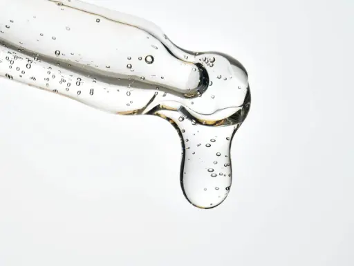 Kwas salicylowy działanie: przejrzysty żel z pęcherzykami powietrza spływa z pipety, obiecując czystą i odświeżoną skórę.