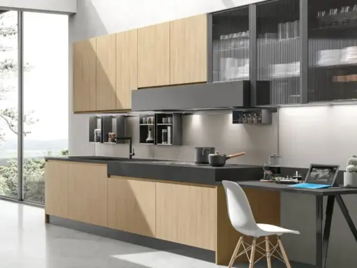 Cucina moderna con ante in legno chiaro e pensili in vetro rigato. Ottime idee cucina piccola per sfruttare ogni spazio.