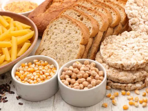 Pain de seigle, pâtes, maïs, pois chiches et galettes de riz. Une variété d'aliments, certains contenant du gluten, d'autres non.