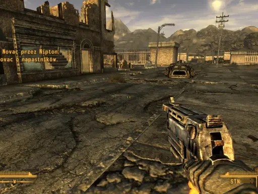 Pustynny krajobraz z ruiny miasta, gracz trzyma broń. W rogu ekranu widać tekst z gry, który sugeruje, że to **fallout new vegas spolszczenie**.