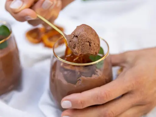 Delicioso mousse de chocolate, perfecto para los postres de Nochevieja. Una cucharada dorada revela su textura aireada.