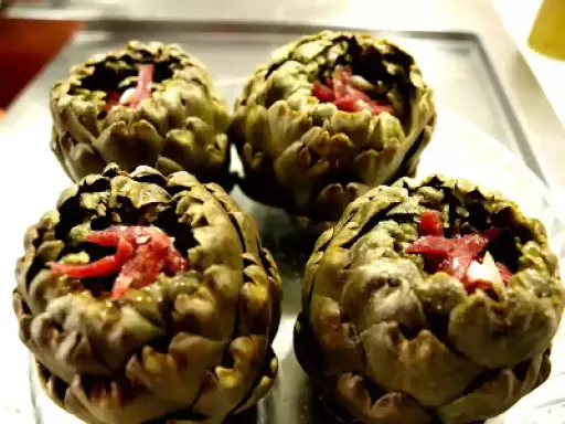 Cuatro alcachofas rellenas de jamón, listas para disfrutar.