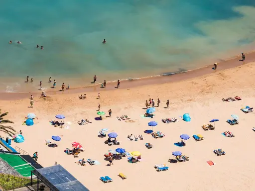 Sonnige Strände auf Madeira, Menschen genießen das Meer und den Sand. Ein entspannter Tag am Strand, vielleicht auch FKK-Bereiche, wie sie auf Madeira üblich sind.