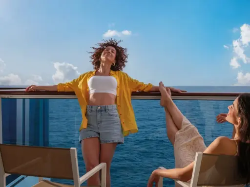 Due donne si godono il sole sul ponte di una nave, con il mare blu all'orizzonte. Una carta costa ideale per una vacanza rilassante.