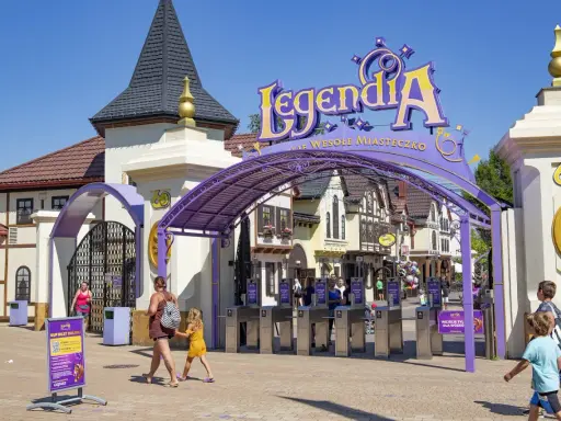 Wejście do Legendii, jednego z najpopularniejszych parków rozrywki w Polsce. Rodziny wchodzą przez bramki.