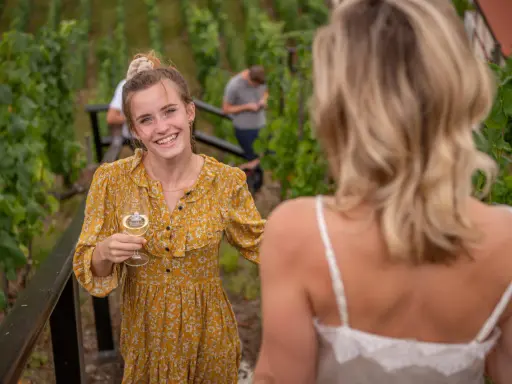 Lachende junge Frau mit Weinglas im Weinberg an der Saale-Unstrut.