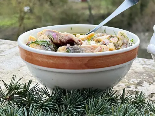 En skål med inlagd sill, dill och blommor. Perfekt för ett svenskt midsommarfirande eller som en del av ett inlagd sill recept.