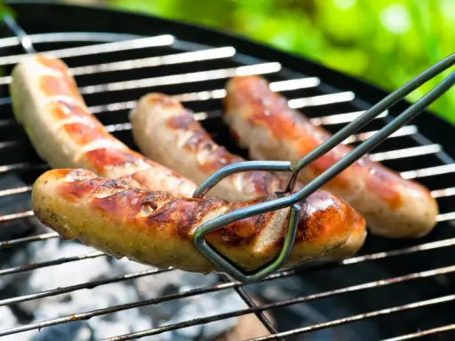 Bratwurst grillen: Saftige Würste brutzeln auf dem Rost, bereit für den Genuss.