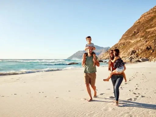 Glad familj på stranden. För att undvika att smittas av hepatit b, undvik delade personliga föremål.