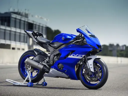 Niebieski motocykl sportowy Yamaha YZF R6 na torze wyścigowym, gotowy do akcji.