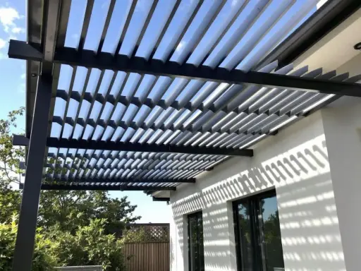 Ombre et lumière sur une maison moderne grâce à l'orientation des lames d'une pergola bioclimatique.