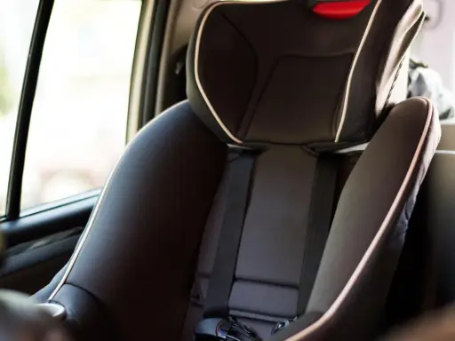 Silla de coche infantil, con cinturón de seguridad y detalles en blanco. La etiqueta indica ece r44/04 vigencia, asegurando su conformidad.