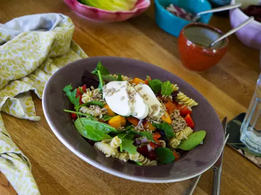 En härlig pastasallad vegetarisk med färska grönsaker, mozzarella och solrosfrön. Perfekt för en lätt lunch.