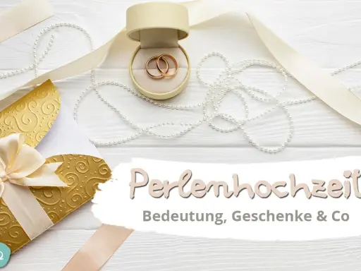 Hochzeitstags-Deko mit Ringen, Perlen und goldenem Umschlag. Die Perlenhochzeit Bedeutung wird hier gefeiert.