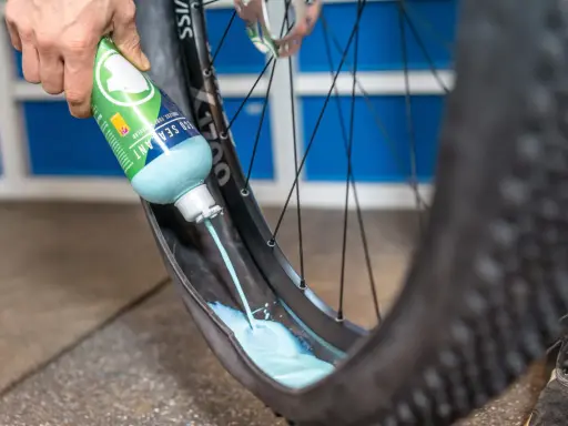 Flüssigkeit wird in einen MTB-Reifen gegossen, um ihn für den Tubeless-Betrieb vorzubereiten. Das ist ein wichtiger Schritt beim MTB Reifen wechseln.